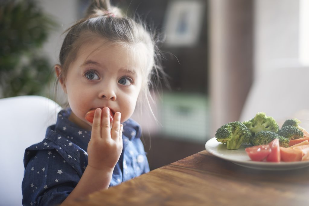 little girl eating vegetables