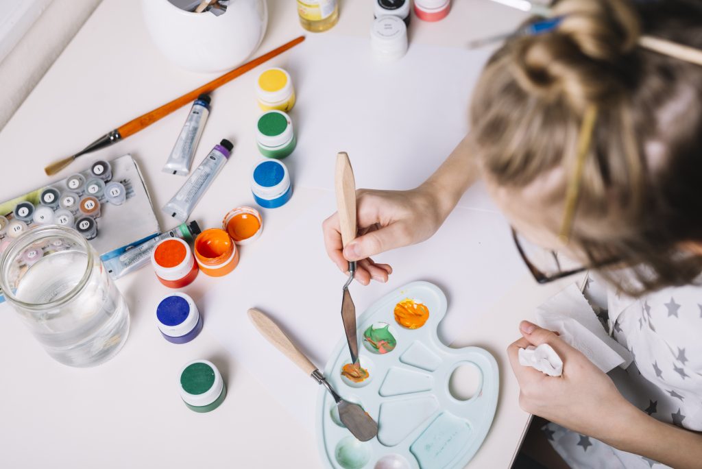 little girl mixing gouache palette table